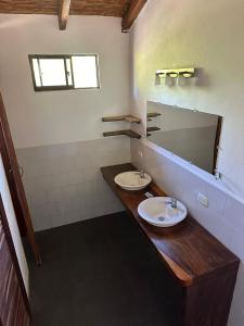a bathroom with two sinks and a mirror at Surfing Turtle Lodge in Poneloya