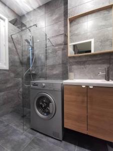 a bathroom with a washing machine and a shower at Le Pressensé in Vénissieux