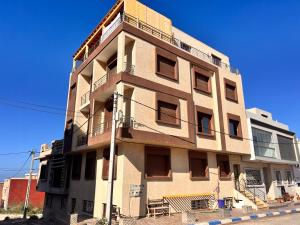 a tall building with balconies on the side of it at Golden WAVE IMSOUANE in Imsouane