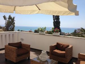 een balkon met 2 stoelen en een parasol bij Casa Vacanze Palma in Realmonte