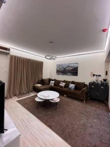 a living room with a couch and a table at شقة غرفة وصالة بلكونه دخول ذكي in Riyadh