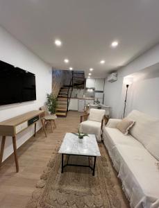 uma sala de estar com um sofá e uma televisão em San Fernando 33 em Córdoba