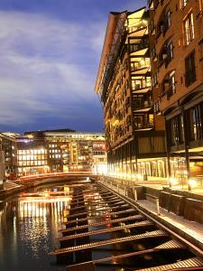 a city street with buildings and a canal at night at Budget Small Room City Centre in Oslo