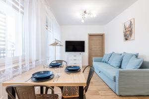 a living room with a table and a blue couch at Lis i Ryś in Ustrzyki Dolne