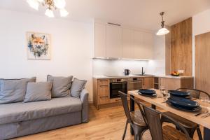 a living room with a couch and a table with chairs at Lis i Ryś in Ustrzyki Dolne +3 photos