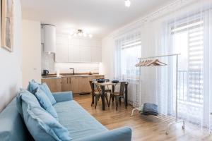 a living room with a blue couch and a table at Lis i Ryś in Ustrzyki Dolne