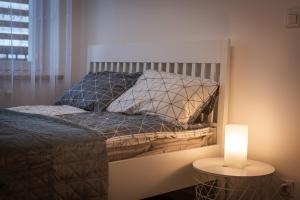 a bedroom with a bed and a lamp on a table at Lis i Ryś in Ustrzyki Dolne