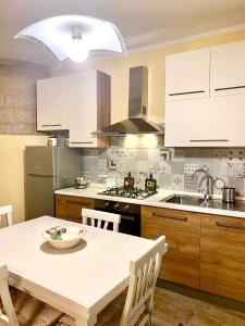una cocina con armarios blancos y una mesa con un tazón. en Casa Vacanze Il Borgo, en Gubbio