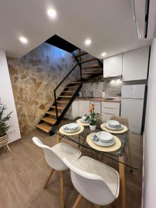 a dining room with a glass table and white chairs at San Fernando 33 in Córdoba
