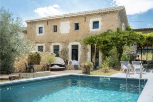 a villa with a swimming pool in front of a house at Chambre d'hôtes de la Savonnerie in Vénéjan
