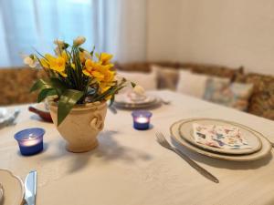 un tavolo con un vaso con fiori gialli di Großes Haus für Monteure a Sandweier