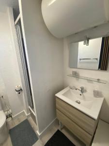 a white bathroom with a sink and a toilet at Studio Centre Port avec piscine résidence Port Richelieu in Cap d'Agde +12 photos