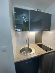 a kitchen with a sink in a counter top at Studio Centre Port avec piscine résidence Port Richelieu in Cap d'Agde