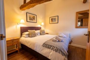 a bedroom with a bed and a wooden floor at Dragonfly Cottage, Canal location in Brecon