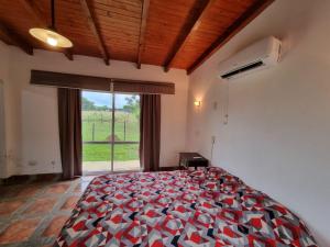 ein Schlafzimmer mit einem Bett und einem großen Fenster in der Unterkunft Rancho Aparte in Ituzaingó