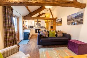 a living room with a couch and a kitchen at Dragonfly Cottage, Canal location in Brecon