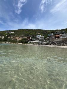 un cuerpo de agua con un grupo de casas en una playa en Espetacular! Casa de Praia em Arraial do Cabo, en Arraial do Cabo
