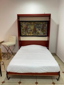 a bed in a room with a painting on the wall at JVD Apartment in Dubai