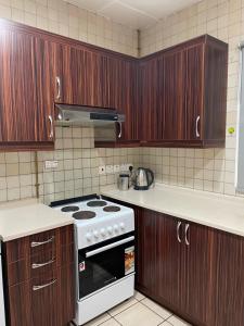 a kitchen with wooden cabinets and a stove top oven at JVD Apartment in Dubai