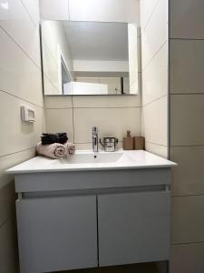 a bathroom with a white sink and a mirror at Sunset suite - step from the beach in Ashkelon