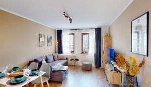 a living room with a couch and a table at CozyHome Hauptmarkt Apartments in Gotha