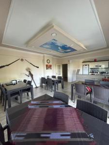 ein Esszimmer mit Tischen, Stühlen und einer Decke in der Unterkunft Sumgayit apart in Cayeli