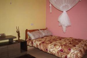 ein Schlafzimmer mit einem Bett mit einer Kommode und einem Fenster in der Unterkunft Ojac Guest House - Iten in Iten