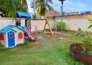 patio trasero con parque infantil con tobogán y patio de juegos en Miramar en Porlamar