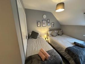 a bedroom with two beds and a mirror at Wembley Serviced Apartment, 20mins from Central London in London
