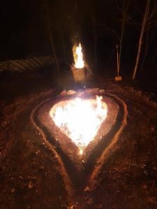 un pozo de fuego con forma de corazón en la nieve por la noche en Slinger Suites en Hendersonville
