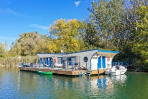 布拉提斯拉瓦的住宿－Očarujúci Houseboat na Dunaji，船屋停靠在水面上