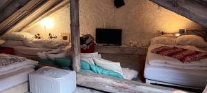 um quarto com um monte de camas e uma televisão em Maison de montagne 2 à 8 couchages proche Barcelonette em Condamine-Châtelard