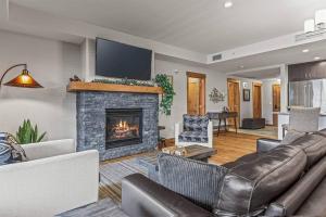 a living room with a couch and a fireplace at Spring Creek Spacious Luxury & Views at White Spruce Lodge in Canmore