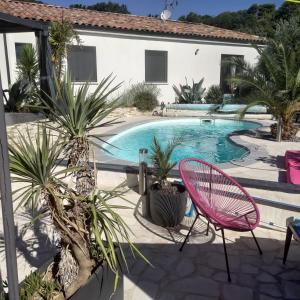 un patio con una silla rosa y una piscina en Partie de villa moderne avec piscine En option jaccuzi dans espace détente indépendant, en Villeneuve