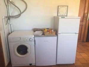 eine Küche mit einer Waschmaschine und einem Kühlschrank in der Unterkunft Chalet de Montagne in Valdeblore