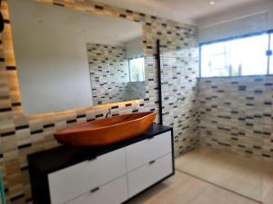 ein Badezimmer mit einem Holzwaschbecken auf einem Schrank in der Unterkunft Fazenda de Jehne - Casa completa in Camamu + 44 Fotos