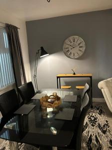 uma sala de estar com uma mesa e um relógio na parede em Manor House em Belfast