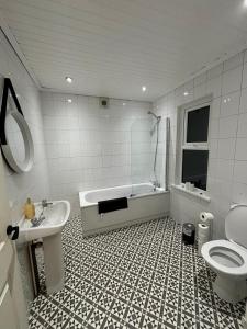 uma casa de banho com uma banheira, um WC e um lavatório. em Manor House em Belfast
