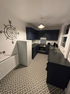 a kitchen with black cabinets and a white refrigerator at Manor House OVER 25 ONLY kids with adults allowed in Belfast +6 photos