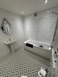 a bathroom with a bath tub and a sink at Manor House in Belfast