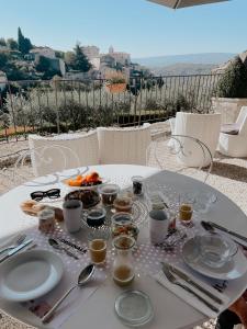 una mesa con platos y utensilios encima en Mas des Romarins, The Originals Relais, en Gordes