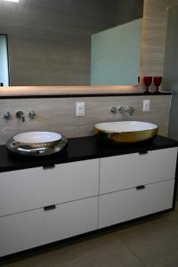 ein Badezimmer mit zwei Waschbecken und einem großen Spiegel in der Unterkunft Fazenda de Jehne - Casa completa in Camamu