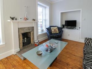 a living room with a table and a fireplace at Lower Neuk in Dunfermline