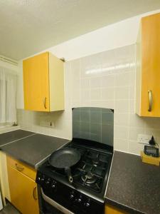 a kitchen with a stove top oven in a kitchen at Spacious One Bedroom Flat close to Heathrow Airport in Northolt