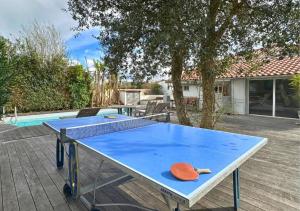 eine Tischtennisplatte im Hinterhof mit Pool in der Unterkunft Villa COLIVING EFFET MER - Nomad Digital - 4 chambres in Anglet