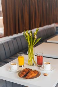 a table with a tray of croissants and cups of coffee at Pontonul de pe Dunăre Giurgiu in Giurgiu +6 photos
