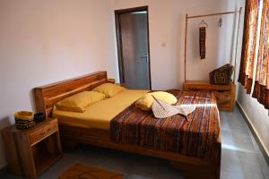 ein Schlafzimmer mit einem Bett mit einem Kopfteil aus Holz in der Unterkunft Les Amazones Rouges Chambre Jaune in Ouidah
