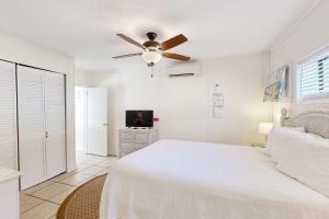 una camera bianca con letto e ventilatore a soffitto di Linda's Cozy Duplex B a Laguna Beach