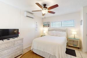 una camera bianca con letto e ventilatore a soffitto di Linda's Cozy Duplex B a Laguna Beach