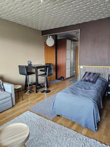 a bedroom with a bed and a table and a piano at Miller Apartment - Free parking, airport 21min in Klaukkala